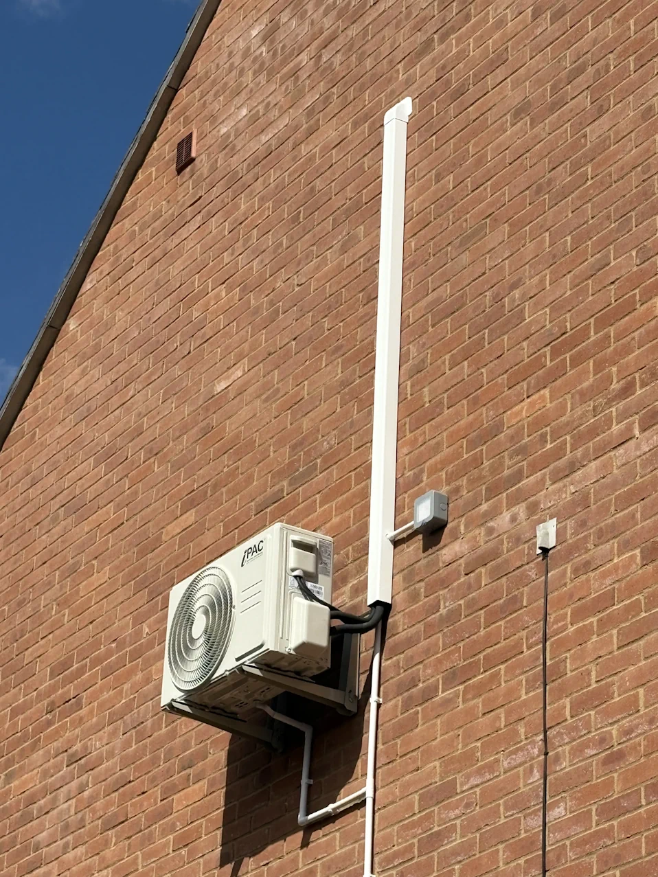 12000BTU air conditioning outdoor unit installed on an outside wall in a 3 storey town house